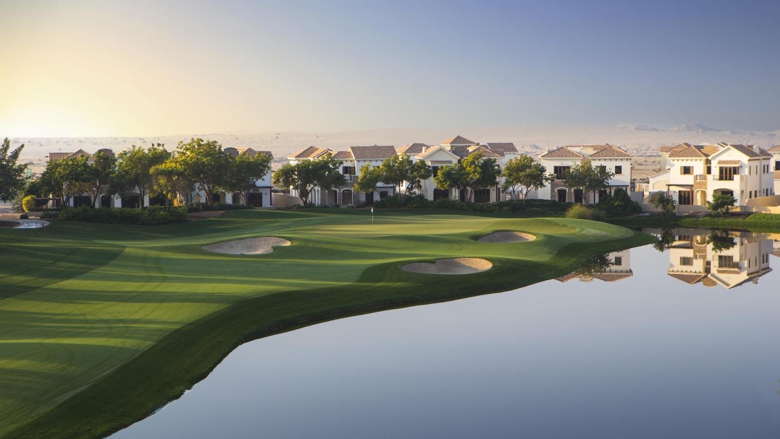 Scenic view of Jumeirah Golf Estates with manicured fairways, water hazards, lush greenery, and luxury villas in the background under a bright sky