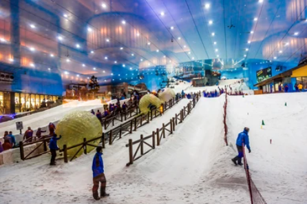 Skiers enjoying the indoor slopes at Dubai Ski Resort, surrounded by artificial snow and winter scenery